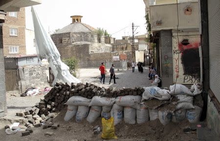 Residents look at a damaged building a day after a security operation in the Kurdish-dominated southeastern city of Diyarbakir, Turkey, September 7, 2015. REUTERS/Sertac Kayar