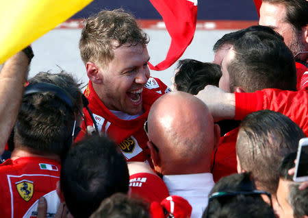 Formula One - F1 - Australian Grand Prix - Melbourne, Australia - 26/03/2017 - Ferrari driver Sebastian Vettel of Germany celebrates with members of his team after winning the Australian Grand Prix. REUTERS/Brandon Malone