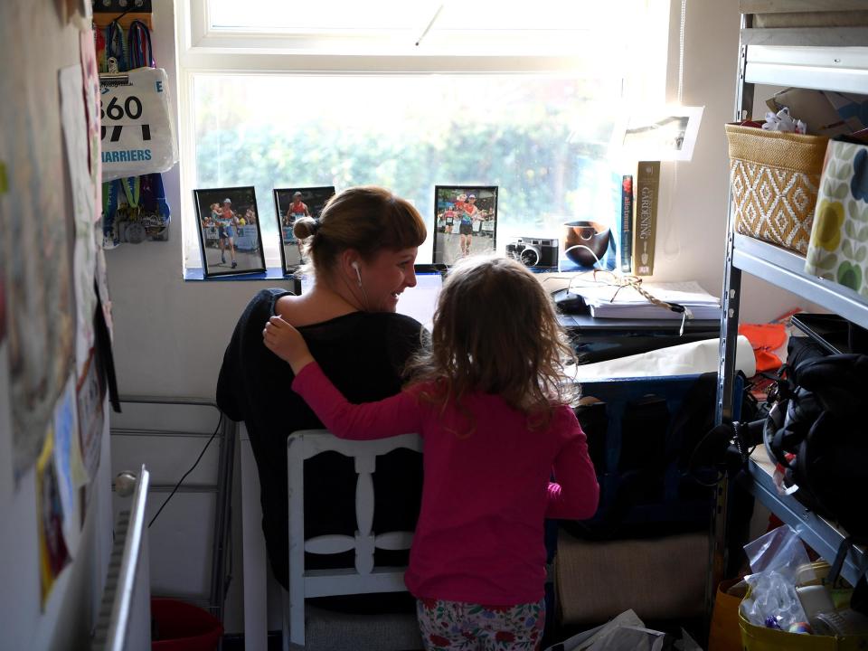 Four-year-old Lois Copley-Jones disturbs her mother Ruth, who is pictured working from home in Newcastle Under Lyme in March: Getty