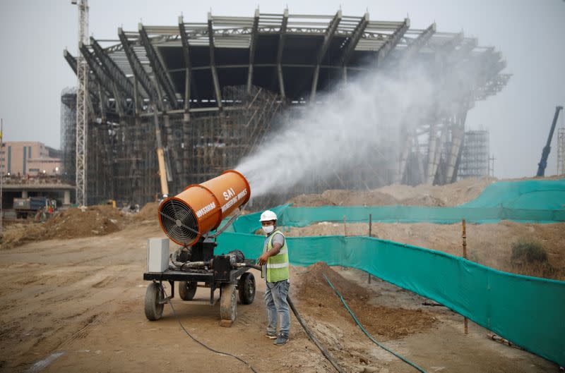 A worker operates an anti-smog gun at a construction site in New Delhi