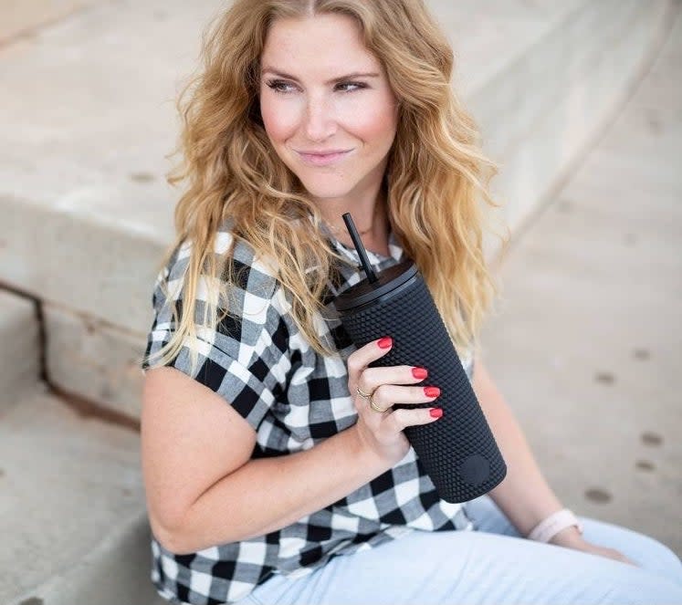 Model holding the black tumbler