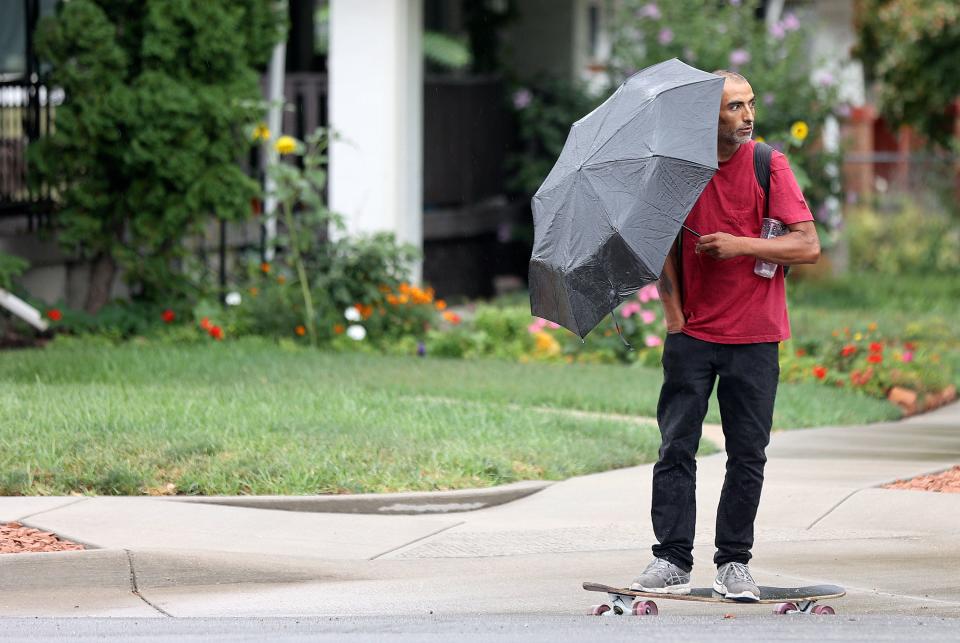 A man skateboards with an umbrella as it rains in Salt Lake City on Tuesday, Aug. 22, 2023. | Kristin Murphy, Deseret News