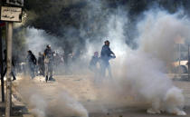 FILE - In this file photo dated Friday, Jan. 14, 2011, a demonstrators throws a stone at police during clashes in Tunis. Tunisia's president declared a state of emergency and announced that he would fire his government as violent protests escalated Friday, with gunfire echoing in the North African country's usually calm capital and police lobbing tear gas at protesters. On Thursday Jan. 14, 2021, Tunisia commemorates 10 years since the flight into exile of its iron-fisted leader, Zine El Abidine Ben Ali, pushed from power in a popular revolt that foreshadowed the so-called Arab Spring.(AP Photo/Christophe Ena, FILE)