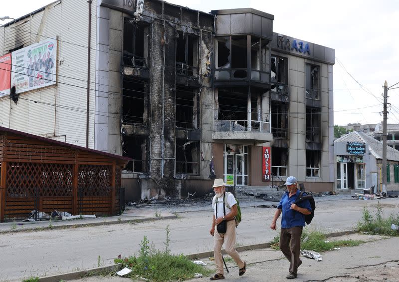 Residentes locales pasan por delante de un edificio destruido durante el conflicto entre Ucrania y Rusia en la ciudad de Lisichansk, en la región de Luhansk, Ucrania