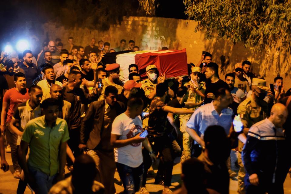 Men carry the coffin of military solider Ahmed Mohamed Ahmed Ali, who was killed in battle, during his funeral service, in Qalyubia province, Egypt, Sunday, May 8, 2022. At least 11 Egyptian troops, including an officer, were killed Saturday, May 7, 2022 in a militant attack on a water pumping station east of the Suez Canal, the military said. (AP Photo/Sayed Hassan)