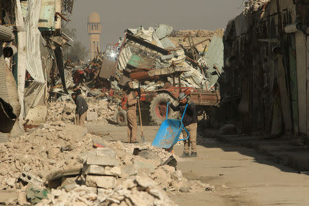 Workers clean the street in Mosul, Iraq, January 10, 2018. REUTERS/Ari Jalal/Files