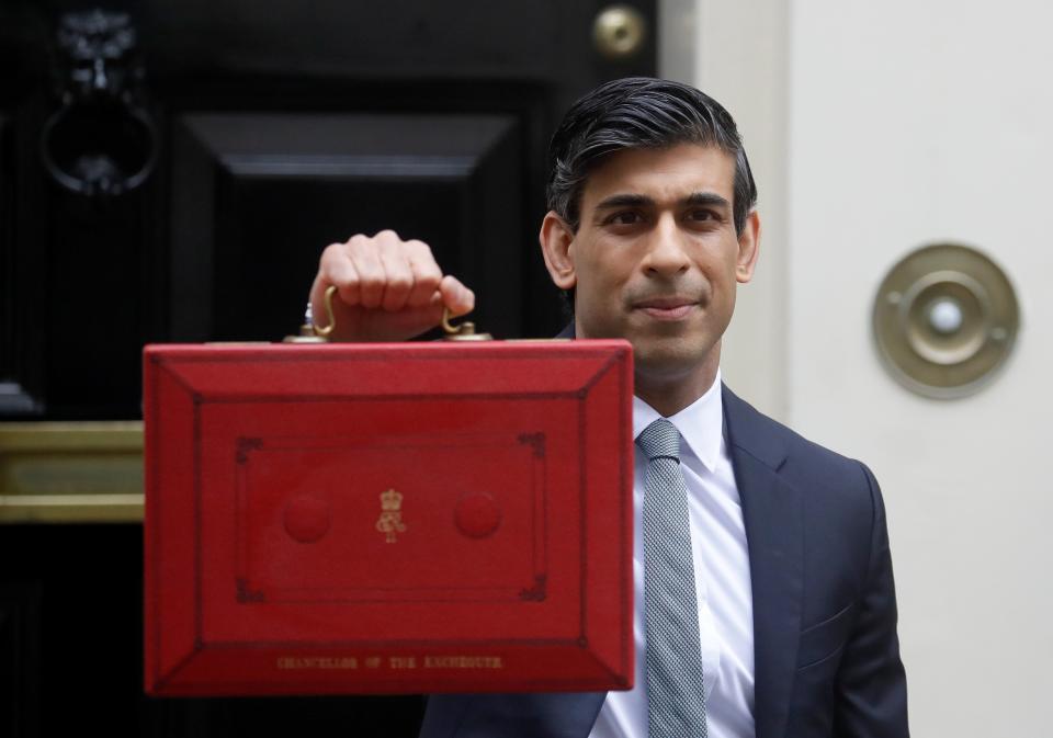 Rishi Sunak stands with his red briefcase in front of 11 Downing Street (AP)