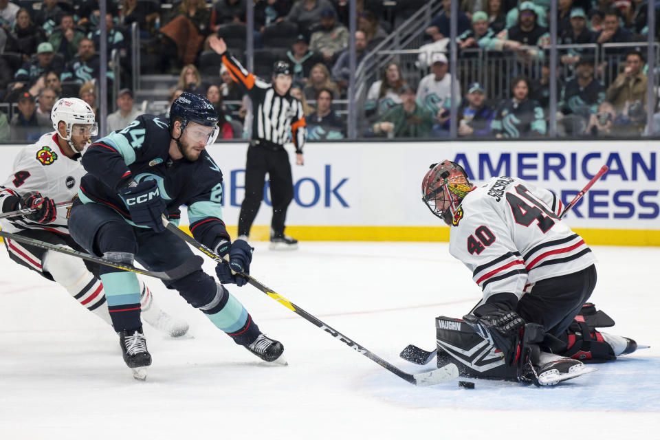 Seattle Kraken defenseman Jamie Oleksiak (24) attempts to score on a breakaway, but Chicago Blackhawks goaltender Arvid Soderblom (40) makes the save during the second period of an NHL hockey game Wednesday, Jan. 24, 2024, in Seattle. (AP Photo/Jason Redmond)