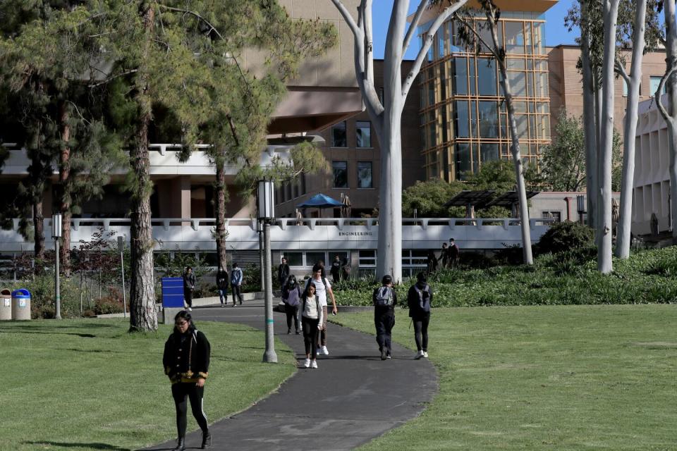 Students and faculty walk through the UC Irvine campus.