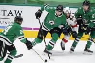 Dallas Stars' Roope Hintz (24), Jamie Oleksiak (2) and Jason Robertson (21) combine to control the puck in front of Florida Panthers left wing Ryan Lomberg (94) in the first period of an NHL hockey game in Dallas, Saturday, April 10, 2021. (AP Photo/Tony Gutierrez)