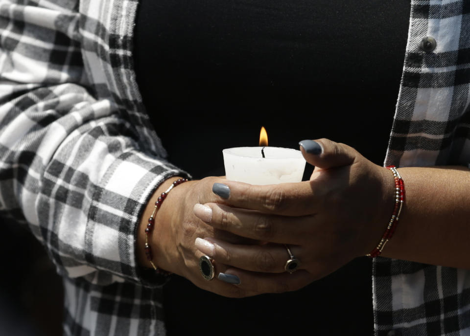 A victim's relative holds a candle during a memorial ceremony in front of the site at Alvaro Obregon 286, where 49 died when their office building collapsed in last year's 7.1 magnitude earthquake, in Mexico City, Wednesday, Sept. 19, 2018. Across the city, memorials were held at sites where hundreds perished in the Sept. 19, 2017 quake.(AP Photo/Rebecca Blackwell)