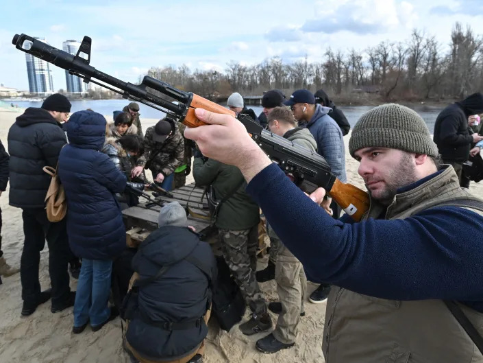 Residents attend an open training organised for civilians by war veterans and volunteers who teach the basic weapons handling and first aid on one of Kyiv's city beaches.