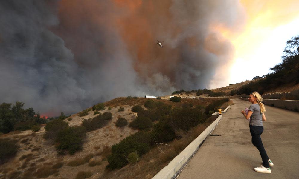 A woman watches a fire that threatens her home in Malibu, 9 November 2018.