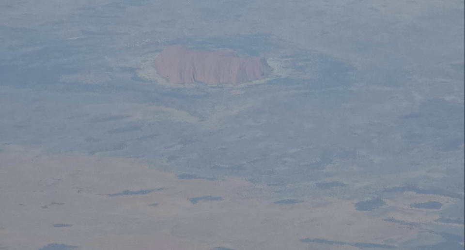 At almost 37,000 feet, Uluru can be seen rising out of the red centre. Source: Facebook