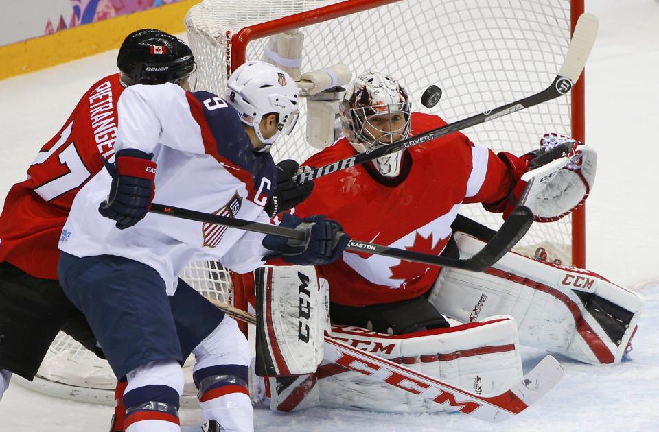 Canada's goalie Carey Price (R) makes a save on Team USA's Zach Parise next to Canada's Alex Pietrangelo (L) during the first period of their men's ice hockey semi-final game at the Sochi 2014 Winter Olympic Games February 21, 2014. REUTERS/Brian Snyder (RUSSIA - Tags: SPORT ICE HOCKEY OLYMPICS)