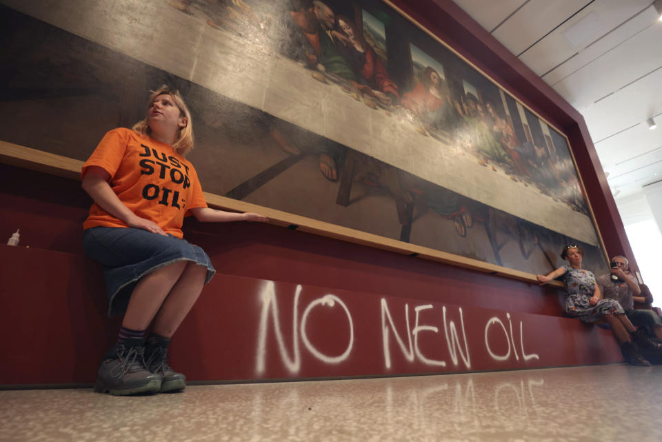 Manifestantes del grupo de protesta climática "Just Stop Oil" pegan sus manos al marco de una copia de "La última cena" de Leonardo da Vinci, el martes 5 de julio de 2022, en la Real Academia de Londres. (James Manning/PA vía AP)