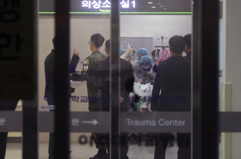 <em>A South Korean army soldier (second from left) is seen as medical members treat the North Korean soldier (AP)</em>