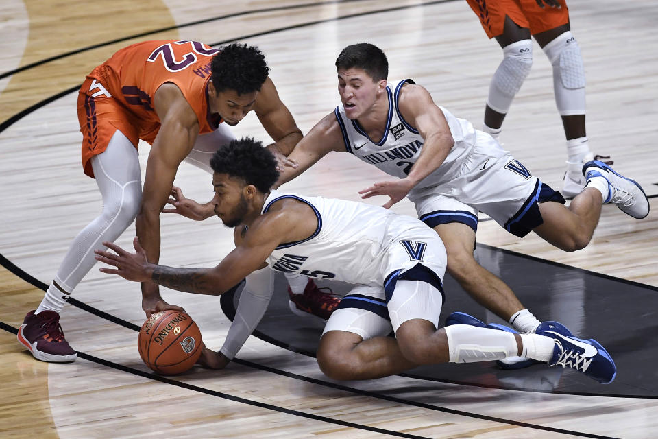 Virginia Tech's Keve Aluma, left, and Villanova's Justin Moore, center, and Collin Gillespie go for a loose ball during the first half of an NCAA college basketball game Saturday, Nov. 28, 2020, in Uncasville, Conn. (AP Photo/Jessica Hill)