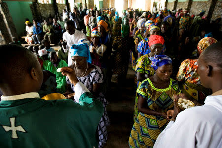 Congolese churchgoers receive communion at Sunday mass in the village of Mweso in eastern Democratic Republic of Congo February 8, 2009. REUTERS/Finbarr O'Reilly/File Photo