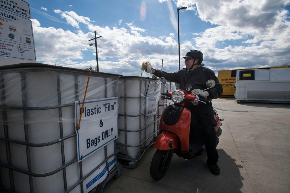 In this file photo, Dave Fritz drives up on his Honda scooter to drop off a few plastic bags into a bin for plastic bags and film at the Timberline Recycling Center in Fort Collins.