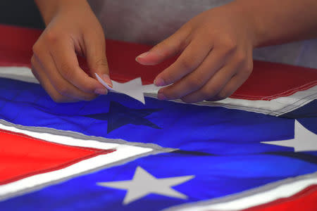 Cynthia Hernandez places stars on a Confederate Battle Flag in the Alabama Flag & Banner shop in Huntsville, Alabama, U.S., August 24, 2017. REUTERS/Harrison McClary