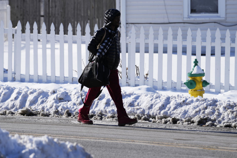 Una transeúnte camina en una calle durante una tormenta invernal el martes 31 de enero de 2023, en Waukegan, Illinois. (AP Foto/Nam Y. Huh)