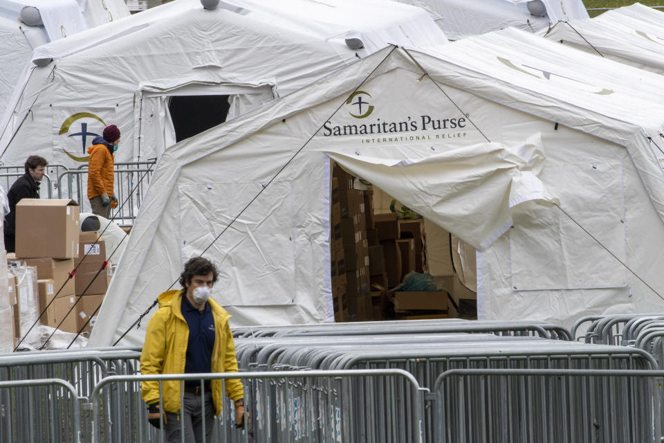 A Samaritan's Purse crew and medical personnel work on preparing to open a 68 bed emergency field hospital specially equipped with a respiratory unit in New York's Central Park, Tuesday, March 31, 2020, in New York. The new coronavirus causes mild or moderate symptoms for most people, but for some, especially older adults and people with existing health problems, it can cause more severe illness or death. (AP Photo/Mary Altaffer)