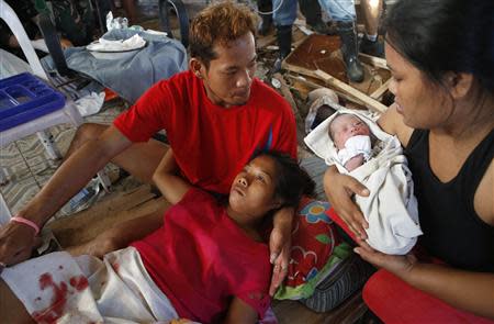 A relative holds newly born baby Beatriz as her mother recuperates at a makeshift birthing clinic in Tacloban city in central Philippines November 11, 2013. REUTERS/Erik De Castro