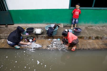 Women wash clothes in water from a tributary of the Citarum river in Majalaya, a town densely populated with textile factories, south-east of Bandung, West Java province, Indonesia, January 25, 2018. REUTERS/Darren Whiteside