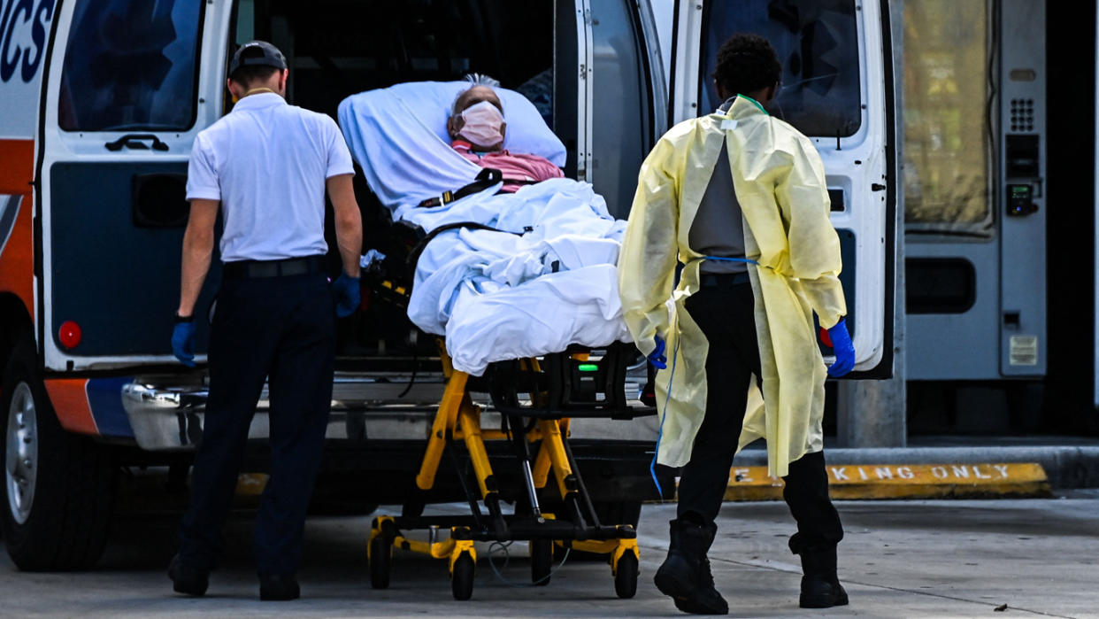 Medics transfer a patient on a stretcher from an ambulance outside of Emergency at Coral Gables Hospital where Coronavirus patients are treated in Coral Gables near Miami, on August 16, 2021. (Chandan Khanna/AFP via Getty Images)