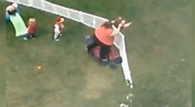 Another video shows a holding a crying child in the air by the legs, lifting her over a fence and then dragging her back inside. Photo: Facebook