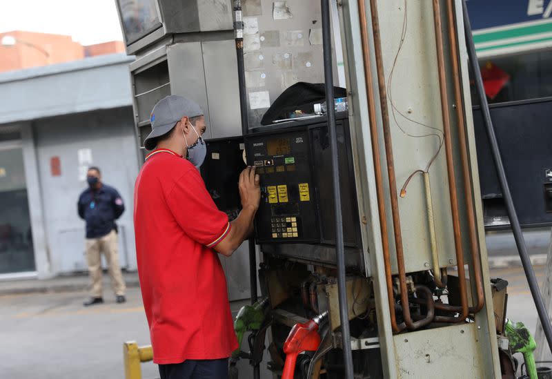 A worker fixes a fuel dispenser machine at a gas station Caracas