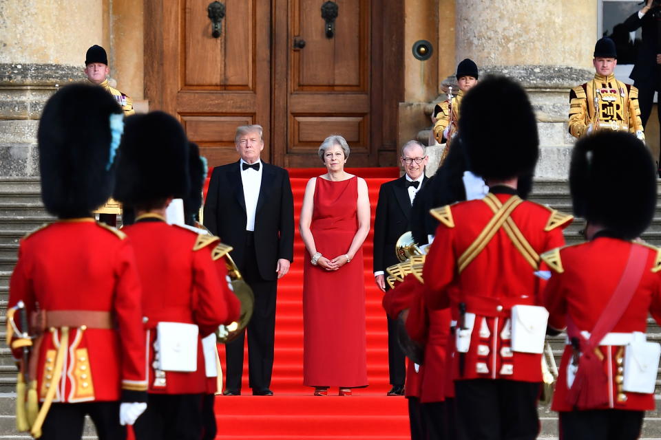 UK01. OXFORDSHIRE (REINO UNIDO), 12/07/2018.- La primera ministra británica, Theresa May (c), y su esposo Philip May (c-d), permanecen junto al presidente estadounidense, Donald Trump (c-i), en los escalones de la Gran Corte mientras las bandas de guardia escocesas, irlandesas y galesas dan la bienvenida ceremonial a Trump hoy, jueves 12 de julio de 2018, en Oxfordshire (Reino Unido). Trump y su esposa, Melania, fueron recibidos hoy en el palacio de Blenheim, en el condado de Oxfordshire (Inglaterra), con una solemne ceremonia militar antes de su cena con empresarios británicos. Trump llegó hoy a Londres procedente de Bruselas para iniciar su primera visita oficial al Reino Unido. EFE/Ben Stansall/POOL