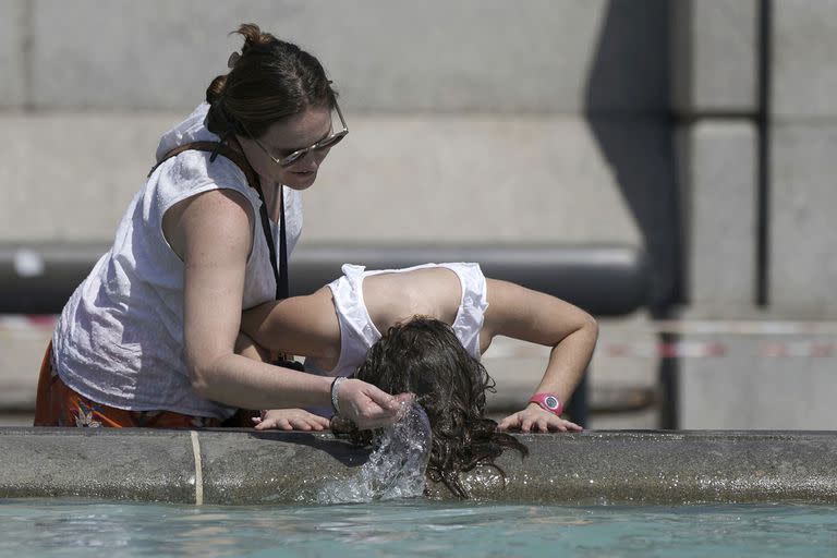 Dos personas se refrescan en Trafalgar Square