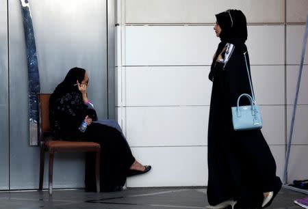 A Saudi woman speaks on the phone as another woman walks past her in Riyadh, Saudi Arabia September 28, 2017. REUTERS/Faisal Al Nasser/Files