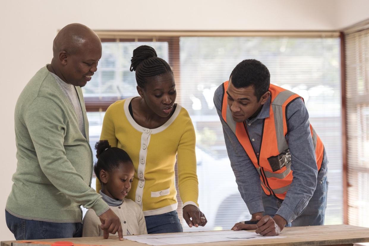 Family with one child looking at renovation plans that the architect prepared