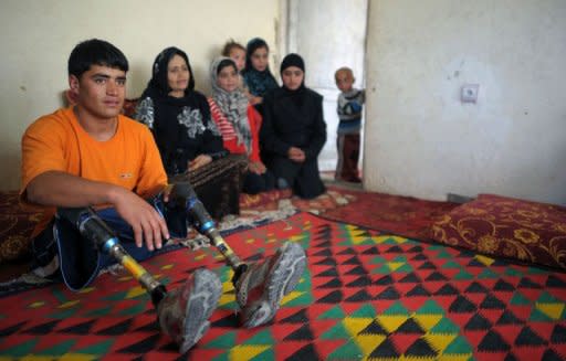 Afghan amputee Malek Mohammad (L) poses with his family at their home in Kabul. Malek appeared on television and newspaper articles were written about him after he won a local swimming competition in San Diego, California, and posed for a calendar of handicapped athletes