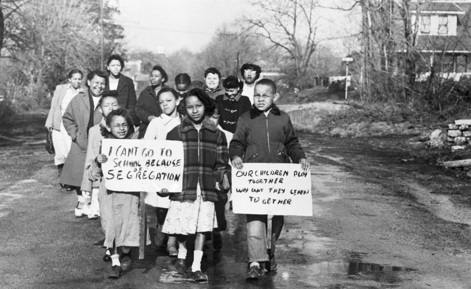 Sixteen Black children accompanied by four mothers carry signs demonstrating their feelings as they walk to Webster School in Hillsboro, Ohio on April 3, 1956, after the U.S. Supreme Court ordered immediate integration at the school on April 2. The children were turned away again as they had been every day for two years. The school board said that it was awaiting official notification of the Supreme Court's decision before taking any action.