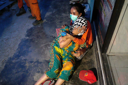 Women cry after identifying the remains of a relative who died in an earthquake in the Balaroa neighbourhood in Palu, Central Sulawesi, Indonesia, October6, 2018. REUTERS/Athit Perawongmetha