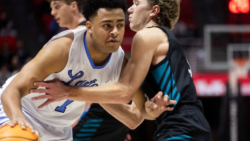 Layton Lancers guard Mekhi Martin (1) drives to the basket against Farmington Phoenix guard Braden Larsen (3) during the 6A high school boys basketball quarter finals at the Huntsman Center in Salt Lake City on Monday, Feb. 26, 2024.