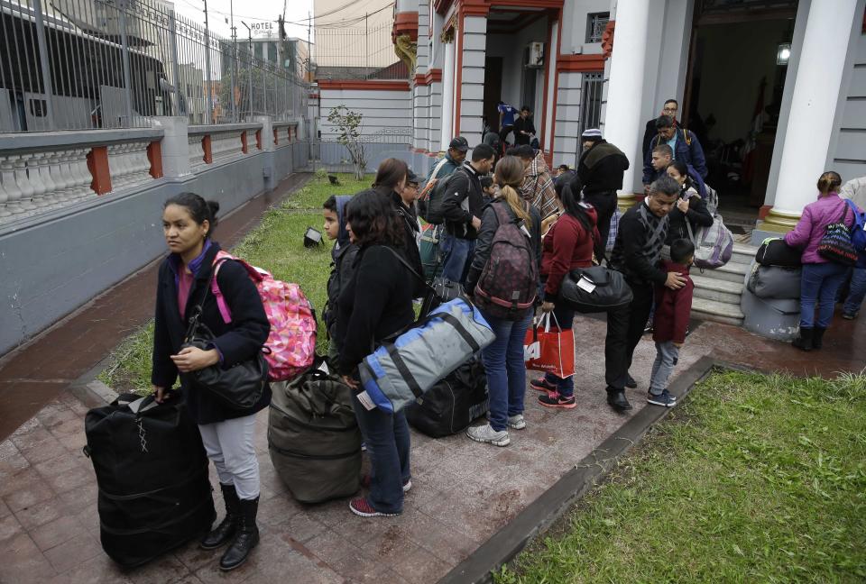 Venezuelan migrants wait outside their country’s embassy for a bus that will transport them to the airport, in Lima, Peru, Monday, Aug. 27, 2018. The Venezuelans are being flown to Caracas on a flight financed by the government of President Nicolas Maduro. (AP Photo/Martin Mejia)