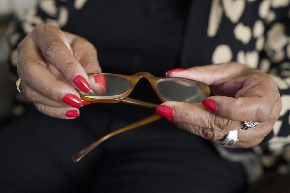 Lee Cole, 74, who is blind, shows the reading glasses with a thick magnifying lens on the right eye that she uses with limited sight since she is completely blind in her left eye, Friday, March 24, 2023, at her Jackson, Miss., apartment. (AP Photo/Rogelio V. Solis)