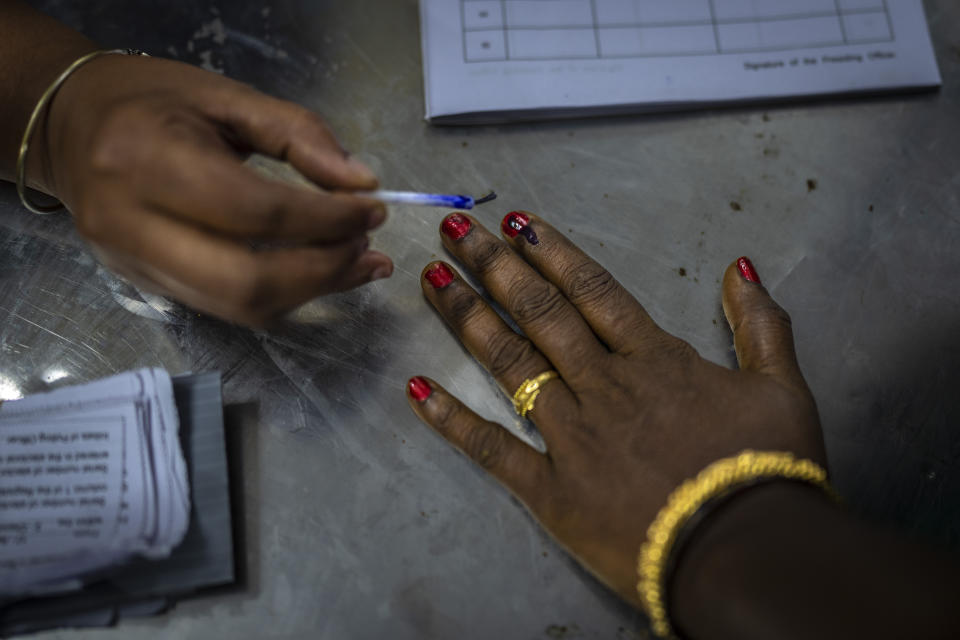 A polling official puts indelible ink mark on the index finger of a woman as she arrives to vote during the first round of voting of India’s national election in Chennai, southern Tamil Nadu state, Friday, April 19, 2024. Nearly 970 million voters will elect 543 members for the lower house of Parliament for five years, during staggered elections that will run until June 1. (AP Photo/Altaf Qadri)