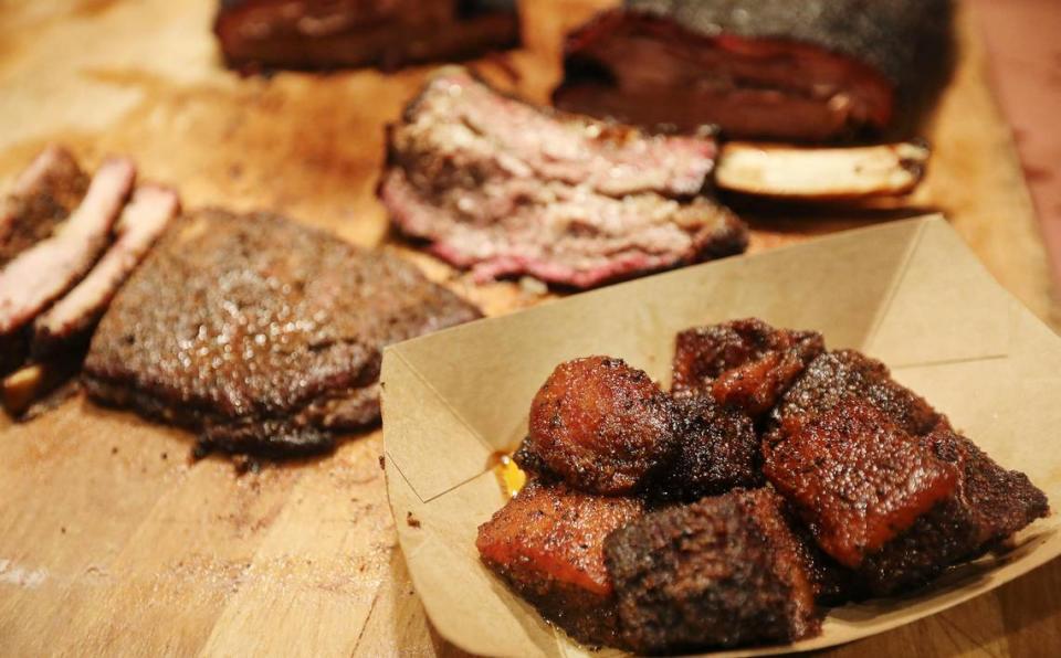 Heim Barbecue’s signature dish, smoked bacon “burnt ends” sit on the board with brisket and ribs.