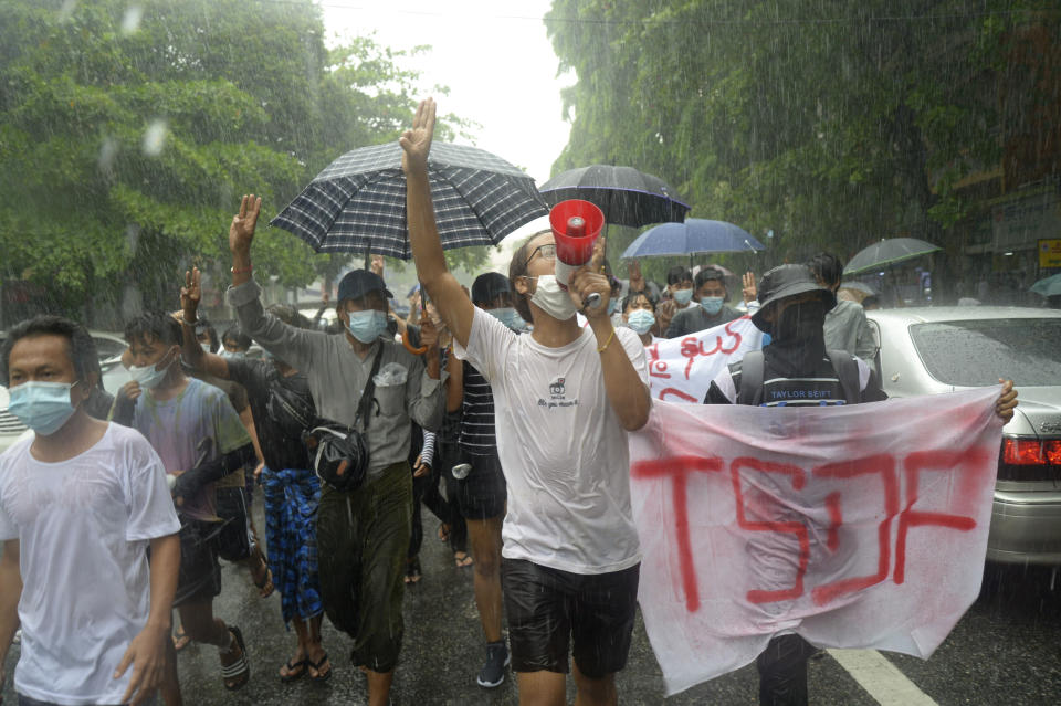 Anti-coup protesters flash the three-finger salute and chant slogans during a demonstration against the military coup in the rain at Pabedan township in Yangon, Myanmar, Friday, April 30, 2021. (AP Photo/Vincent Thian)