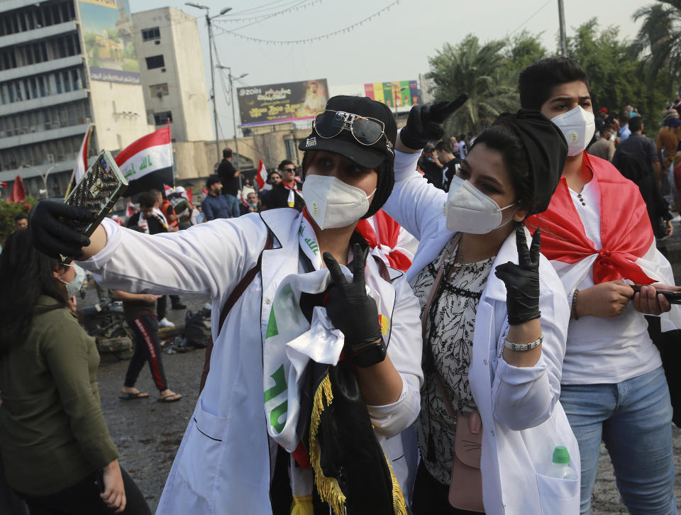 Students take a picture while anti-government protesters gather in Tahrir square during a demonstration in Baghdad, Iraq, Wednesday, Oct. 30, 2019. Anti-government protests in Iraq gained momentum Wednesday with tens of thousands of people gathered in a central square in Baghdad and across much of the country's Shiite-majority central southern provinces. (AP Photo/Hadi Mizban)