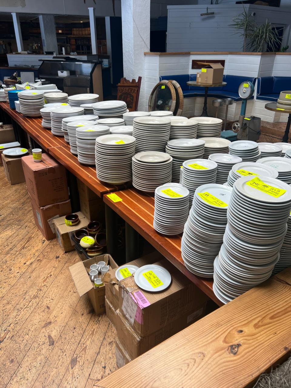 Yellow sale tags abound on plates, equipment and more at the Waterway Cafe in preparation for an auction on Saturday, Aug. 26, 2023, at the Palm Beach Gardens restaurant. The chairs and all other equipment and furnishings will be for sale.