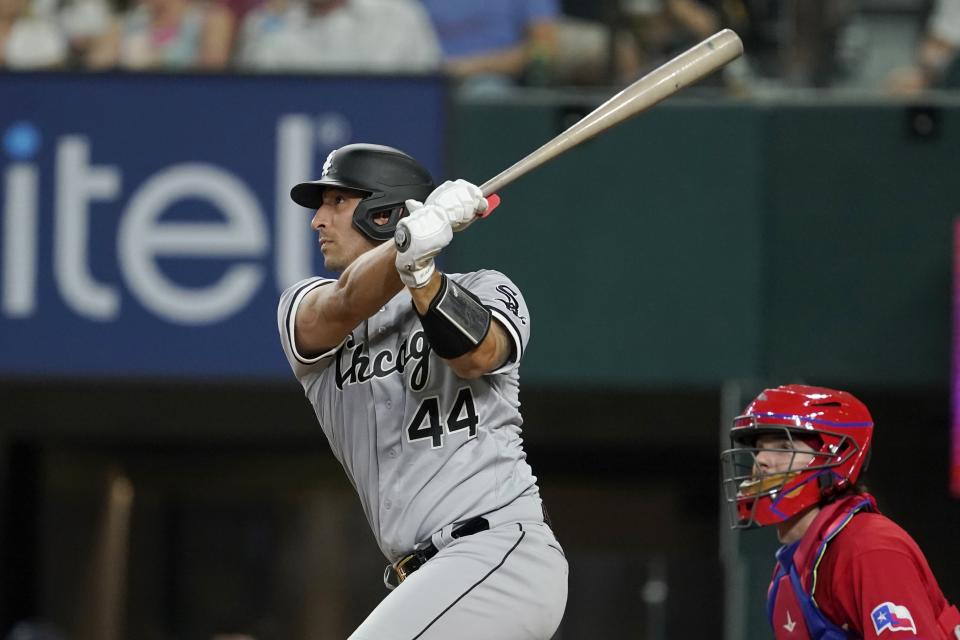 Chicago White Sox's Seby Zavala follows through on RBI sacrifice fly during the third inning of a baseball game as Texas Rangers catcher Jonah Heim looks on, Friday, Aug. 5, 2022, in Arlington, Texas. (AP Photo/Tony Gutierrez)