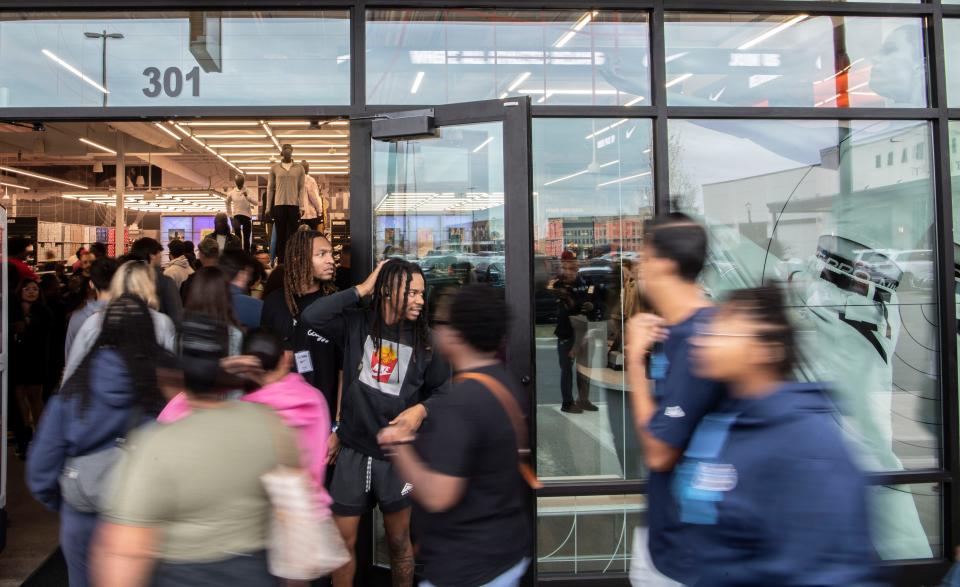 Darrion Gilyard stands outside the Nike store greeting everyone walking inside at the Tanger Outlet in Antioch, Tenn., Friday, Oct. 27, 2023.