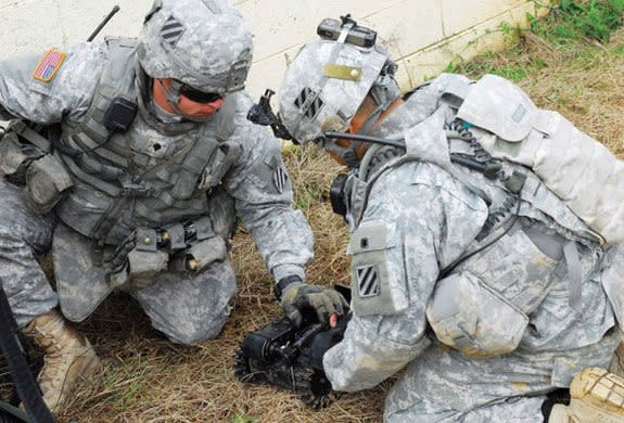 Two Soldiers prepare a robot for a mission Wednesday as part of the experiment at Fort Benning, Ga.